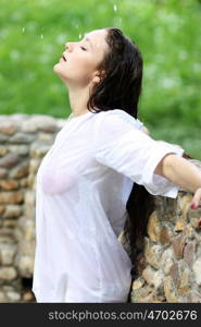 Young happy woman wet in the rain