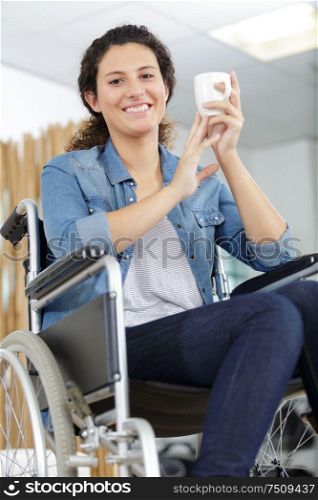 young happy woman wheelchair drink