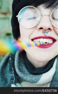 Young happy woman with a rainbow straw