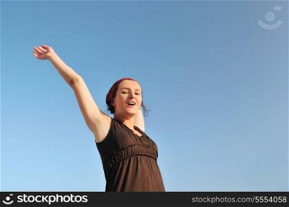 young happy woman with arms wide open representing freedom concept