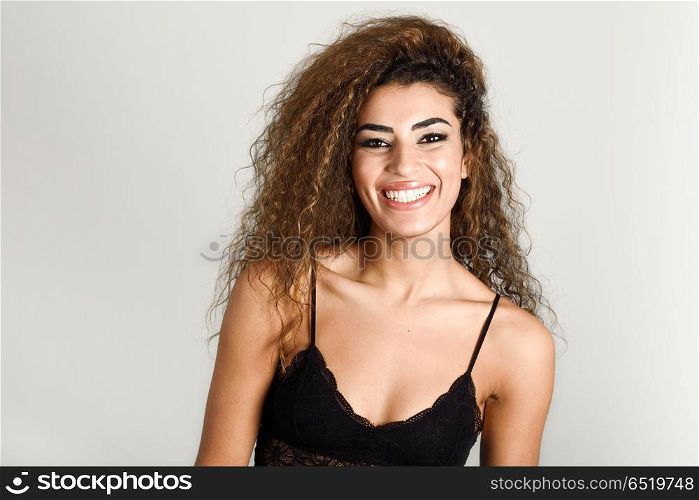Young happy woman with curly hairstyle smiling. Young happy woman with curly hairstyle smiling. Studio shot.