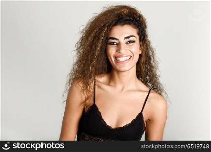 Young happy woman with curly hairstyle smiling. Young happy woman with curly hairstyle smiling. Studio shot.