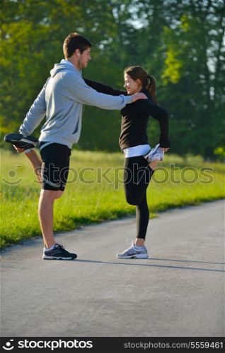 young health couple doing stretching exercise relaxing and warm up after jogging and running in park