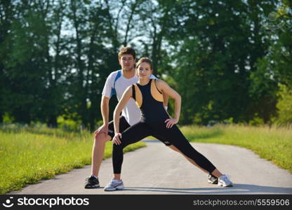 young health couple doing stretching exercise relaxing and warm up after jogging and running in park