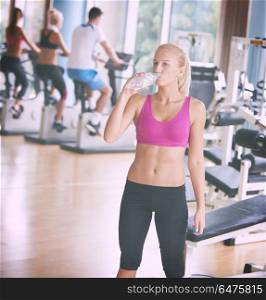 young healthy blonde woman in fitness gym drink water. woman in fitness gym drink water
