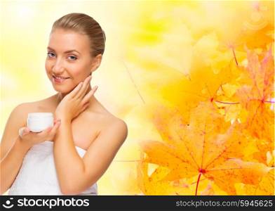 Young healthy girl with body cream on autumnal background