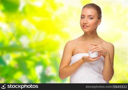 Young healthy girl with body cream on floral spring background