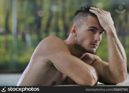 young healthy good looking macho man model athlete at hotel indoor pool