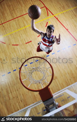 young healthy man play basketball game indoor in gym