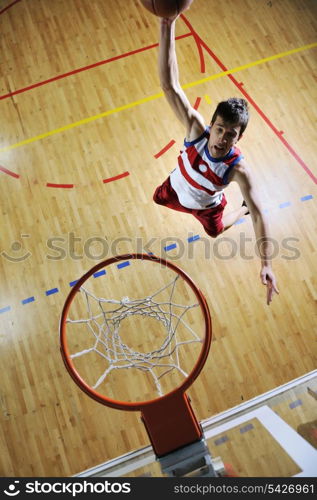 young healthy man play basketball game indoor in gym