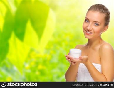 Young healthy woman with body cream on spring background