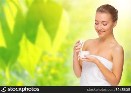 Young healthy woman with body cream on spring background