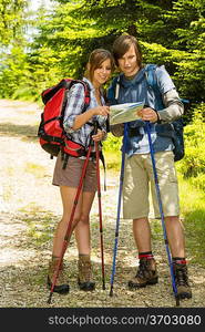 Young hiker couple standing and checking the map in nature