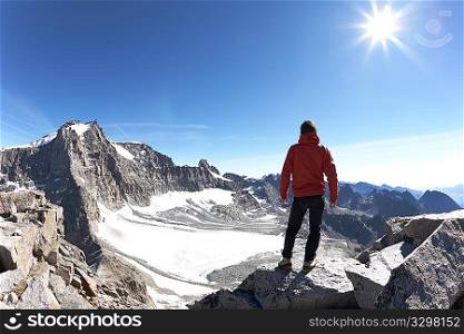 Young hiker enjoying the view over the beautiful landscape of Gran Paradiso National Park, Italy