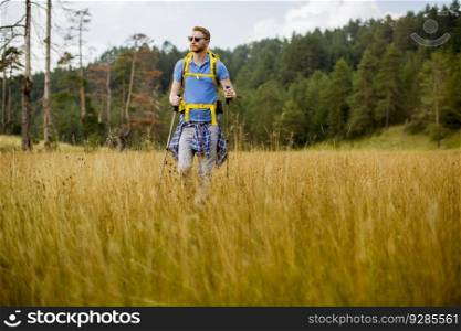 Young hiker enjoys a sunny day on the mountain and walking