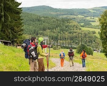 Young hikers with sticks enjoying scenic view on the mountain
