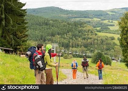 Young hikers with sticks enjoying scenic view on the mountain
