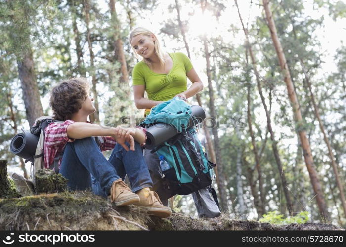 Young hiking couple looking at each other in forest