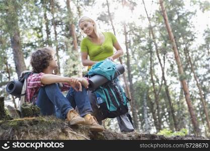 Young hiking couple looking at each other in forest