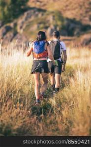 Young hiking couple on hilly trail