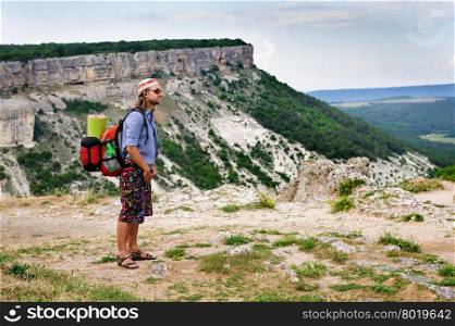 Young hiking man in the rays of sunset, standing at the top of Tope Kermen, Crimea, Ukraine