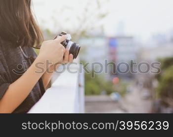 Young hipster girl using analog film camera