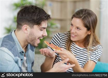 young hipster male and female couple home eating pizza
