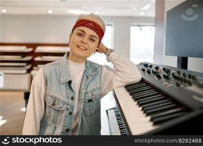 Young hipster woman at synthesizer while choosing new musical instrument at modern shop store. Woman and synthesizer at music shop store