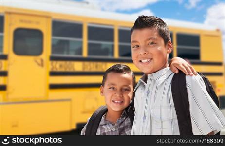 Young Hispanic Boys Walking Near School Bus.