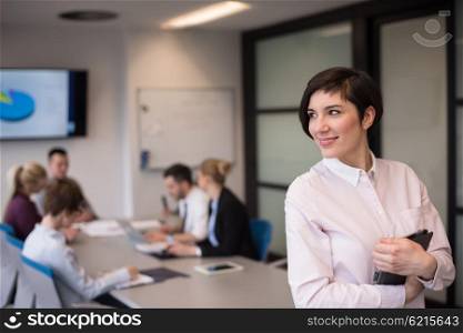 young hispanic businesswoman portrait with tablet computer at modern startup business office interior, people group on team meeting blured in background