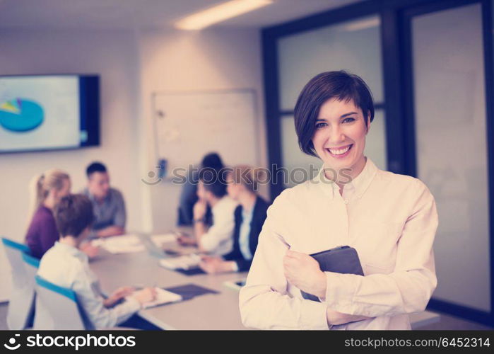 young hispanic businesswoman portrait with tablet computer at modern startup business office interior, people group on team meeting blured in background