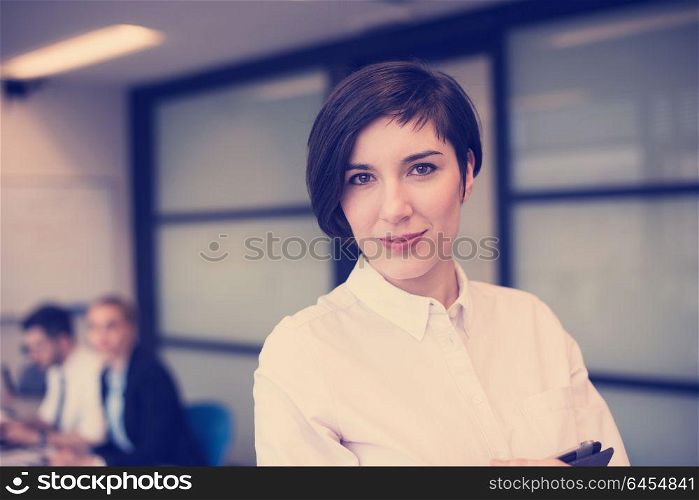 young hispanic businesswoman portrait with tablet computer at modern startup business office interior, people group on team meeting blured in background