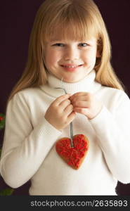 Young Holding Heart Shaped Cookie In Studio