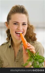 Young housewife eating fresh carrot