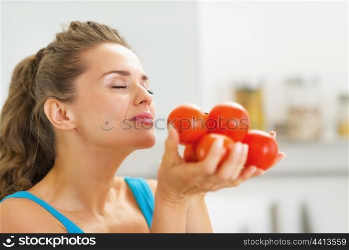 Young housewife enjoying bunch of fresh tomato