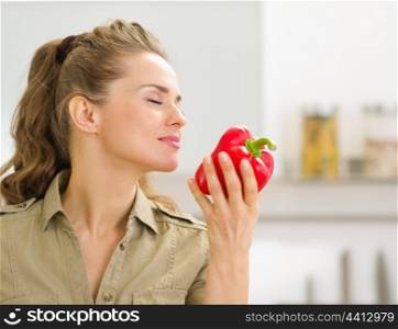 Young housewife enjoying fresh red bell pepper