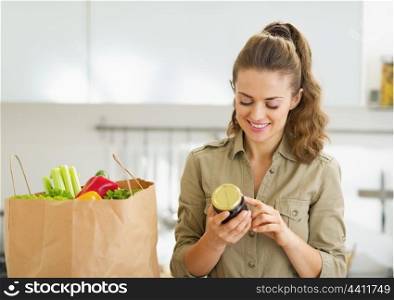 Young housewife exploring purchasings after shopping in kitchen