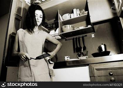 Young housewife holding a fish slice