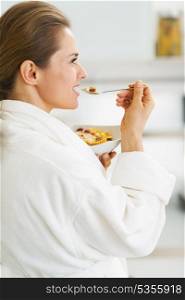 Young housewife in bathrobe having healthy in kitchen