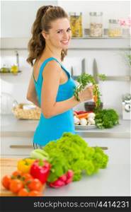 Young housewife preparing vegetables in kitchen