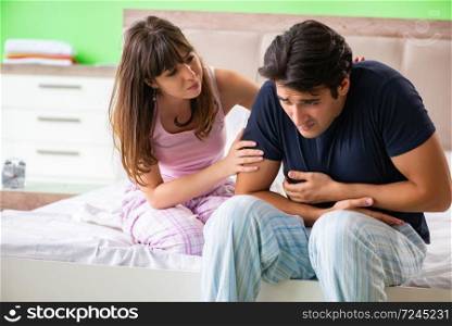 Young husband having problems with health in bedroom 
