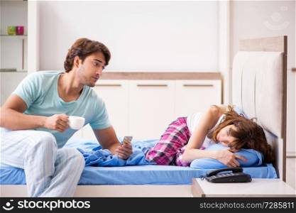 Young husband looking after sick wife in the bedroom 