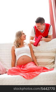 Young husband making present to pregnant wife