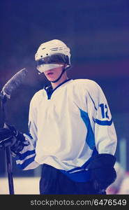 young ice hockey player portrait on training in black background. ice hockey player portrait