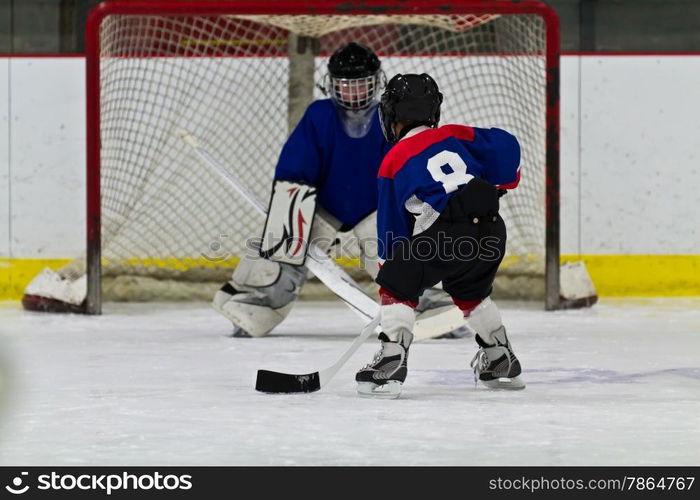 Young ice hockey player prepares to shoot on net