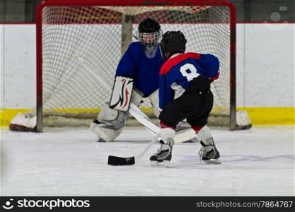 Young ice hockey player prepares to shoot on net