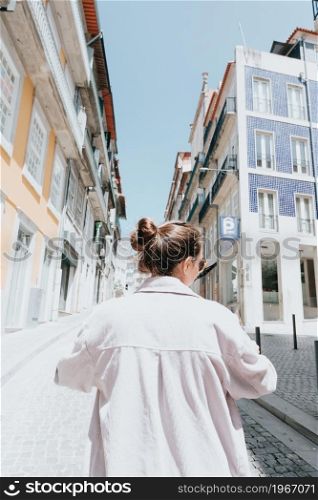 Young indie woman using a map in the middle of a street in europe, sunny day, summer day, travel concepts, new horizons