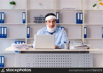Young injured male employee working in the office 