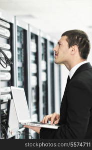 young it engeneer business man with thin modern aluminium laptop in network server room