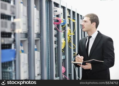 young it engeneer business man with thin modern aluminium laptop in network server room